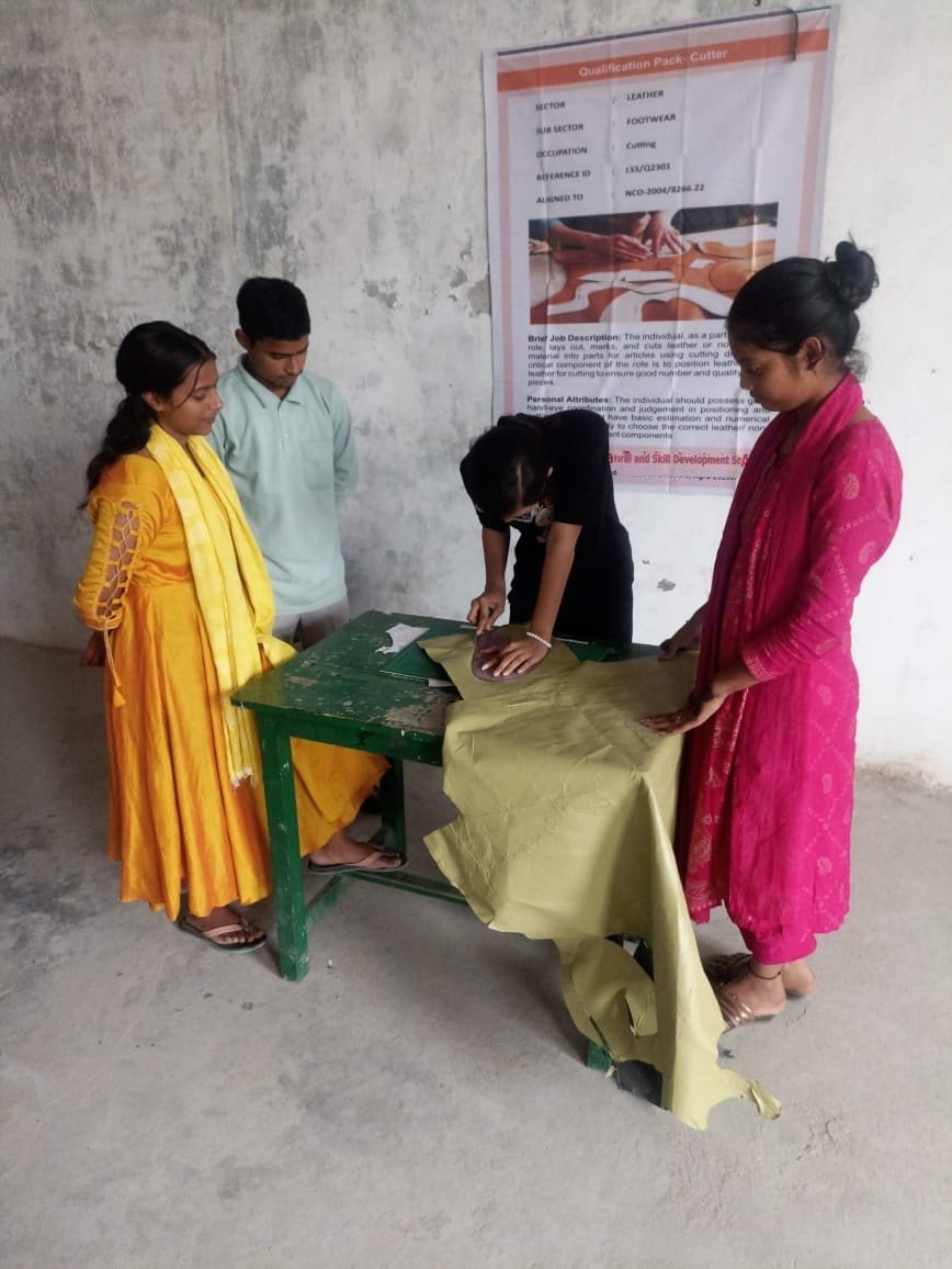 Trainer demonstrating leather work to a group of trainees